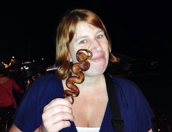 Travel blogger Anja Beckmann eats a snake in Cambodia.