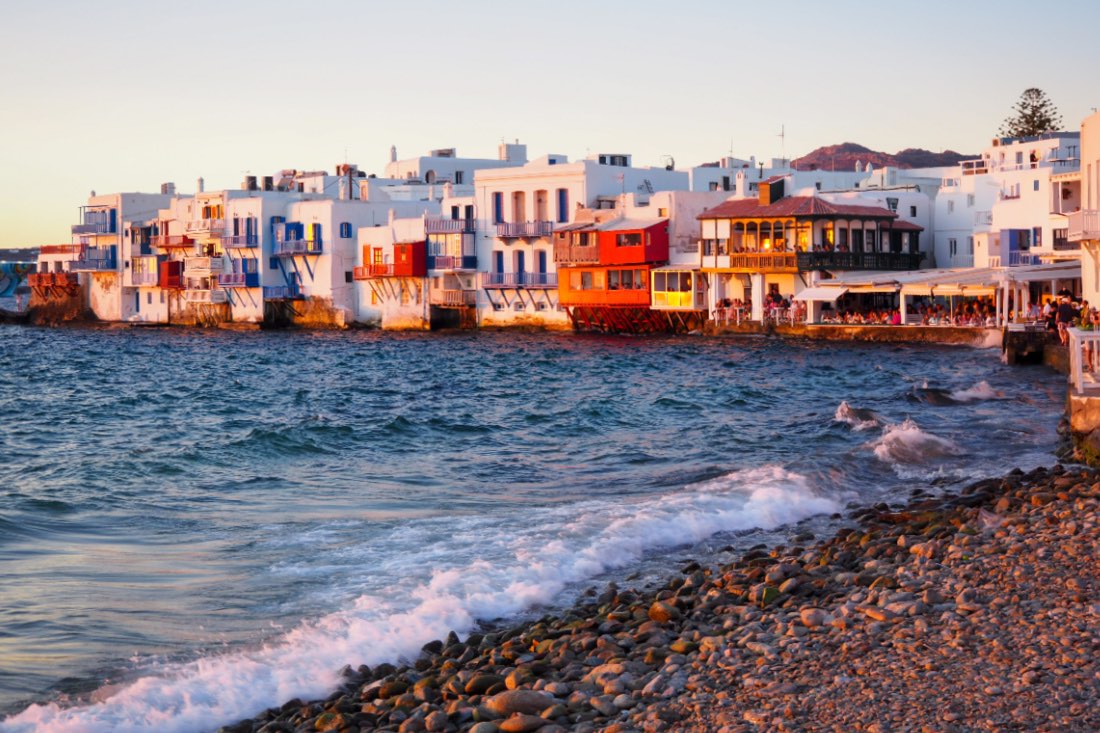 Little Venice auf Mykonos mit weiß-bunten Häusern am Meer zum Sonnenuntergang