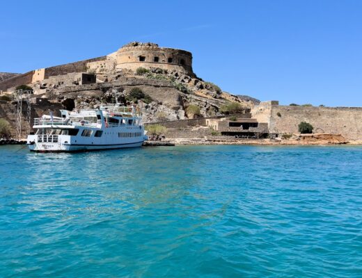 Beim Ausflug von Kreta zur Insel Spinalonga legt das weiße Boot an der ehemaligen Festung und Leprakolonie an.