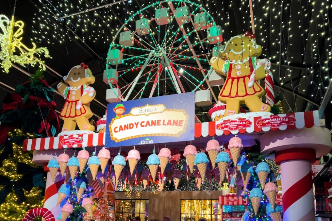 Der Weihnachtsladen in Holland Leurs Venlo mit einem Torbogen, auf dem Candy Cane Lane zu lesen ist. Darauf stehen ein Riesenrad und zu beiden Seiten Lebkuchenfiguren.