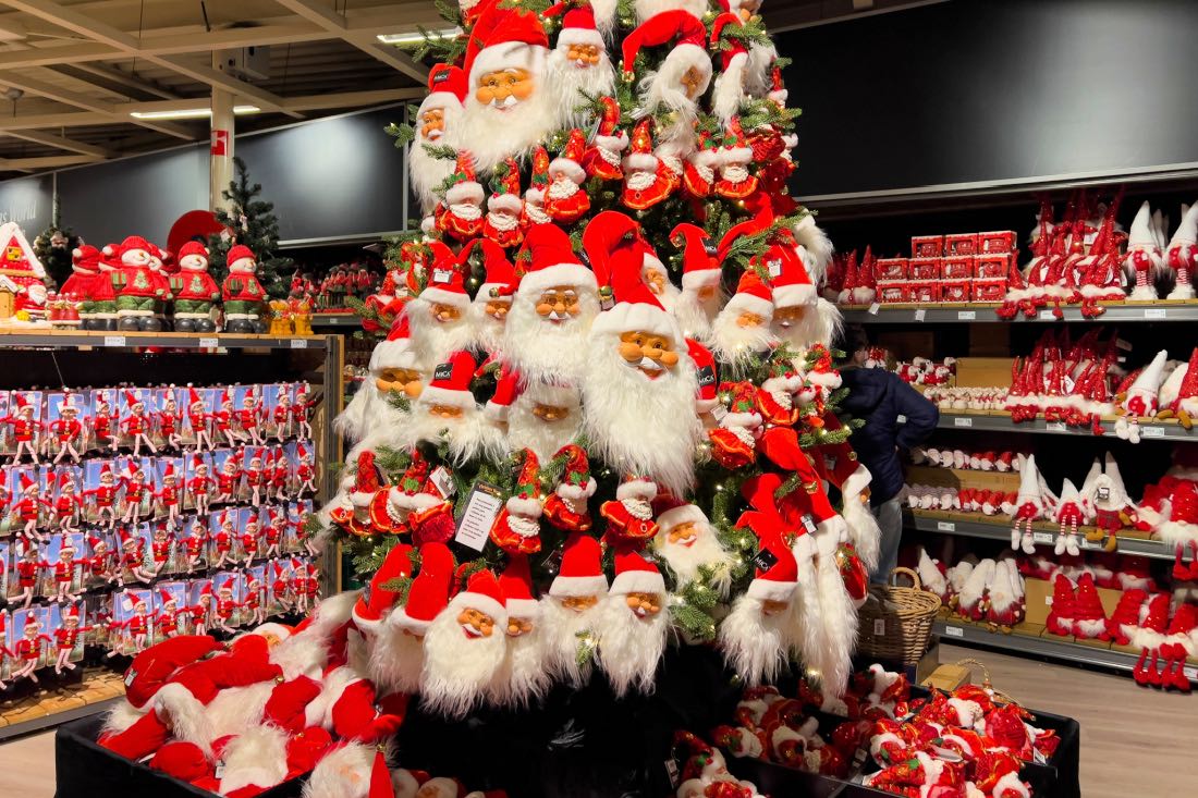Größter Weihnachtsladen Hollands: Gartencenter Intratuin Duiven mit einem Weihnachtsbaum aus Nikolausfiguren, mit Weihnachtsdeko im Hintergrund.