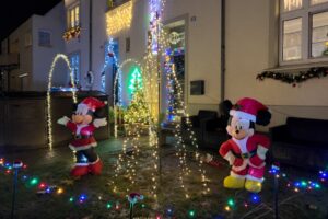 In der Webersiedlung stehen in einem Vorgarten zwei Disney Figuren bei einem Tannenbaum