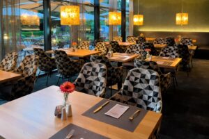 Hotel Restaurant vom Seepark Janssen mit Tischen, Stühlen und Lampen.
